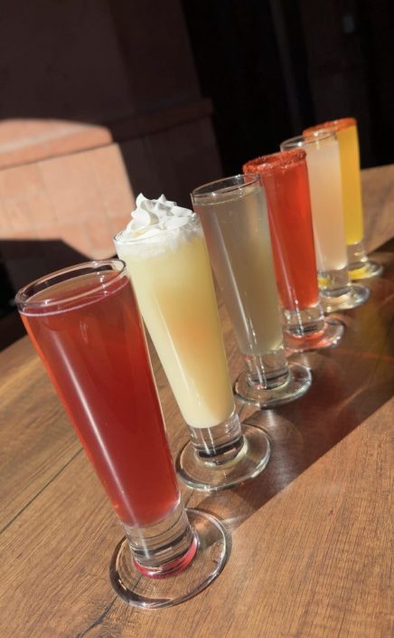 Row of colorful brunch drinks in tall glasses