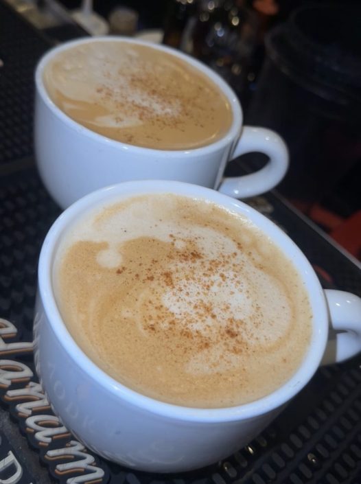 Two cappuccinos dusted with cinnamon