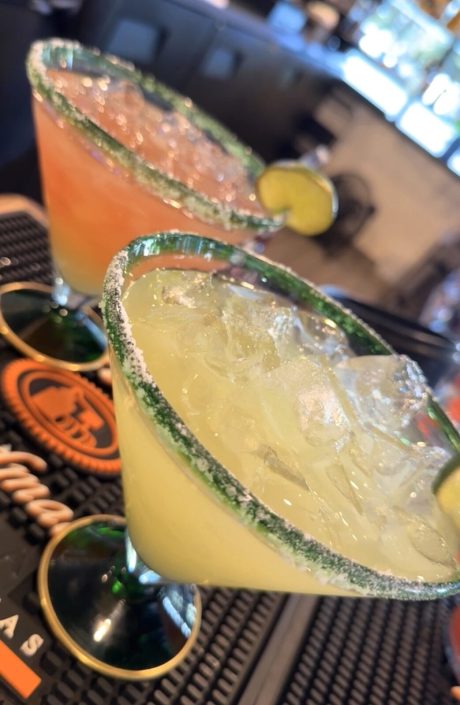 Two margaritas with salted rims at the bar