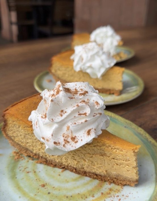 Pumpkin cheesecake topped with whipped cream and cinnamon